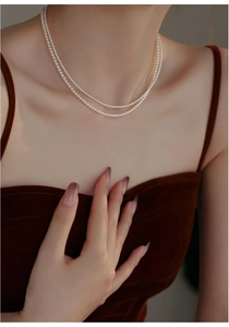Close-up of double-layer freshwater pearl choker necklace on a dark velvet dress