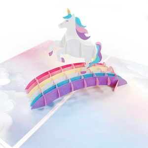 3D pop-up birthday card featuring a white unicorn on a rainbow bridge with clouds