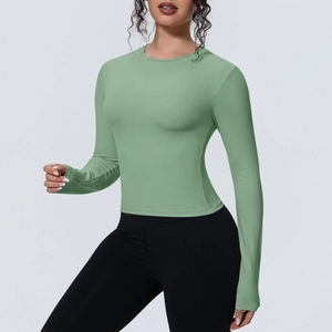 Détail d'un haut de yoga vert clair montrant des coutures plates sur les poignets