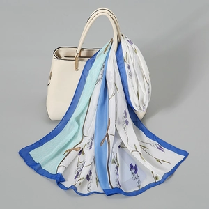 Lightweight floral chiffon silk scarf with blue borders draped over a white handbag