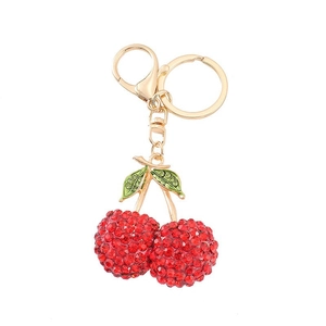 Sparkling cherry keychain with red rhinestones and green enamel on a golden metal ring