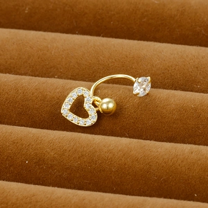 Macro detail of a gold-plated heart navel ring with sparkling cubic zirconia on velvet