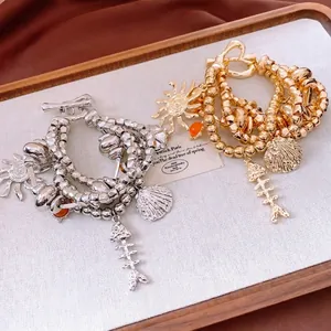 Vintage multi-layered beaded bracelet with sun, shell and fishbone charms on wooden tray