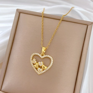 Detail of gold hollow heart necklace with pavé crystal halo on white silk fabric