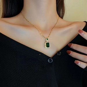 Elegant gold necklace featuring a rectangular emerald green pendant and zircon accents