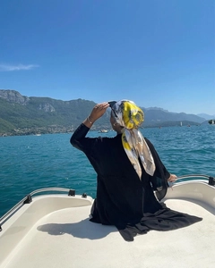 Close-up of yellow and beige satin headscarf worn by a woman on a scenic boat trip