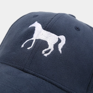 Primer plano del bordado de caballo en una gorra de béisbol de ante azul marino