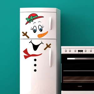 Detailed view of DIY snowman magnet set with red hat and carrot nose on white fridge
