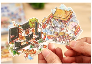 Detail showing hands holding Chinese myth stickers with palace and character illustrations