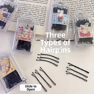 Detail of black bobby pins and wave hair clips in a cute cartoon storage box on a desk