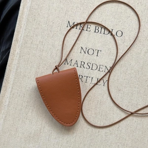 Macro shot of brown pebble grain leather key case with fine stitching on a vintage book