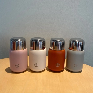 Detailed set of four mini stainless steel insulated cups in pink white orange and grey