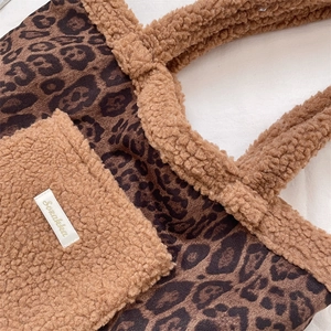 Close-up of leopard print plush tote bag featuring faux shearling pocket and fabric label