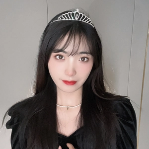 Détail d'une couronne en strass argentés et d'un collier de perles sur un modèle