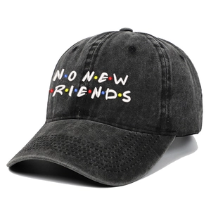 Close-up of No New Friends white embroidery on washed black cotton baseball cap