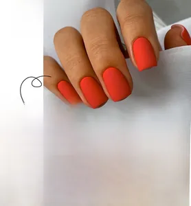 Detailed view of matte bright orange press-on nails in a short square shape style
