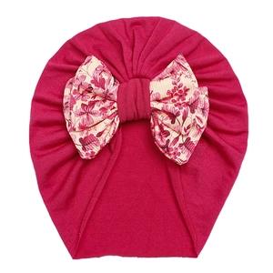 Infant turban hat in dark rose red with a large floral bow detail for baby girls