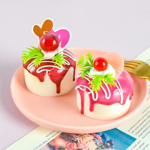 Detailed close-up of fake fruit cake models with glossy syrup and cherry toppings