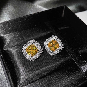 Detailed macro view of luxury square yellow diamond stud earrings in a black velvet jewelry box