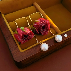 Détails des boucles d'oreilles rose bordeaux avec chaînes dorées et perles blanches