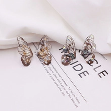 Detailed macro view of S925 silver butterfly earrings with floral print and sequins