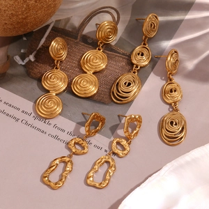 Détail de boucles d'oreilles dorées 18K avec texture martelée irrégulière et forme spirale