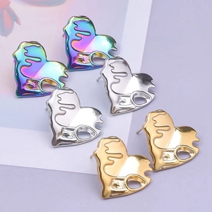 Detailed set of melting heart studs in iridescent, silver, and gold stainless steel