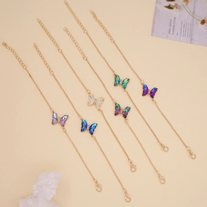 Detailed view of six gold-tone butterfly necklaces with colorful gradient pendants