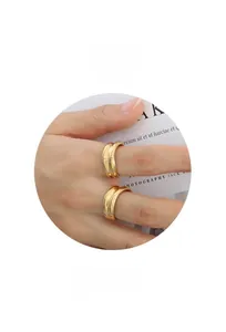 Close-up of double-layer minimalist 18k gold rings with polished finish and curved design