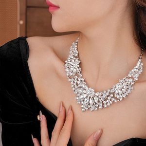 Detailed view of silver flower necklace with sparkling cubic zirconia on neck