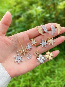 Macro shot of gold and silver plated four-leaf clover charms with inlaid zircon details
