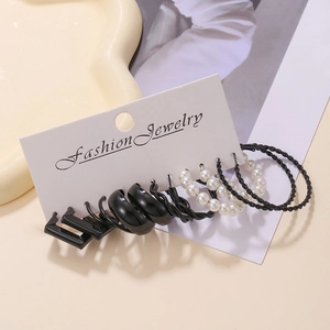 Detail of 6-pair earring set featuring black C-shape hoops and white pearl studs on a card