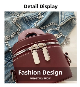 Détail du mini sac seau bordeaux avec fermetures éclair argentées sur du denim