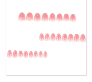 Detailed flat lay of 24 pieces round pink gradient fake nails with white polka dots