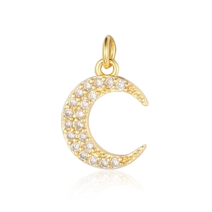 Macro detail of a moon shaped gold pendant with cubic zirconia inlay and reflection