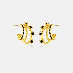 Macro detail of gold-plated silver C-shaped earrings with layered black stone inlay