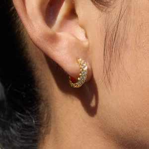 Boucles d'oreilles créoles dorées en acier inoxydable avec cristaux sur un mannequin