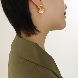Vintage style gold stainless steel fan-shaped earrings with textured finish on a model