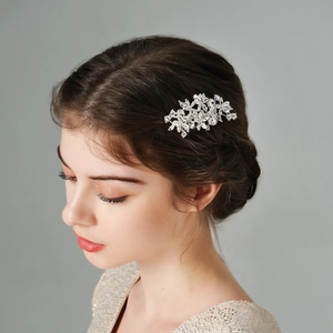Détail du peigne de mariée avec fleurs en strass sur une coiffure chignon élégante
