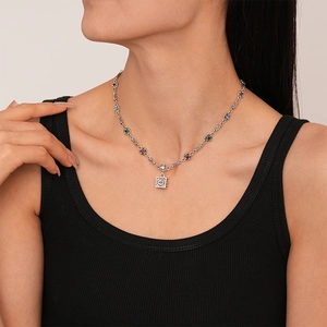 Detailed macro view of vintage silver square pendant necklace with colorful gemstones