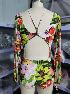 Dettaglio posteriore del costume intero a fiori con maniche lunghe e lacci incrociati sulla schiena