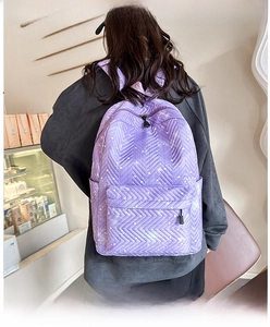 Detalle de mochila acolchada morada con estampado de corazones y costura chevron