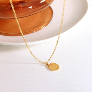 Gold leaf engraved oval pendant necklace on a delicate minimalist chain for women