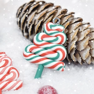 Detailed view of a red and green striped Christmas tree pendant on artificial snow