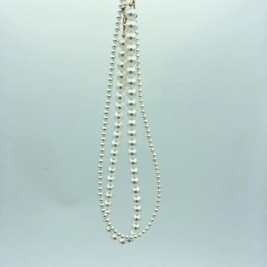 Detail of multi-layered lustrous white pearl necklace with adjustable gold-plated clasp
