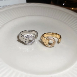 Macro detail of gold and silver leopard head rings with sparkling pavé micro-inlaid zircons