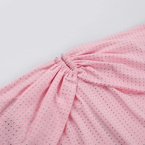Detail of pink fabric with sparkling silver rhinestones and elegant ruched texture