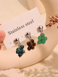 Detailed macro view of three grape-style cluster drop earrings in polished stainless steel