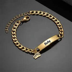 Gold Cuban link bracelet with Baby engraved nameplate and crown charm detail
