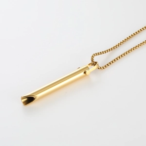 Detail of a golden mindfulness breathing pendant necklace with polished cylinder on a chain
